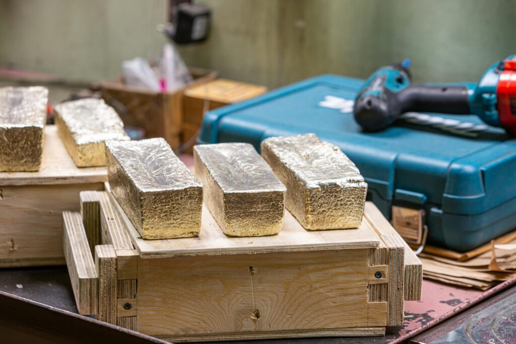 Gold bars in a workshop, highlighting metalwork and industrial themes.